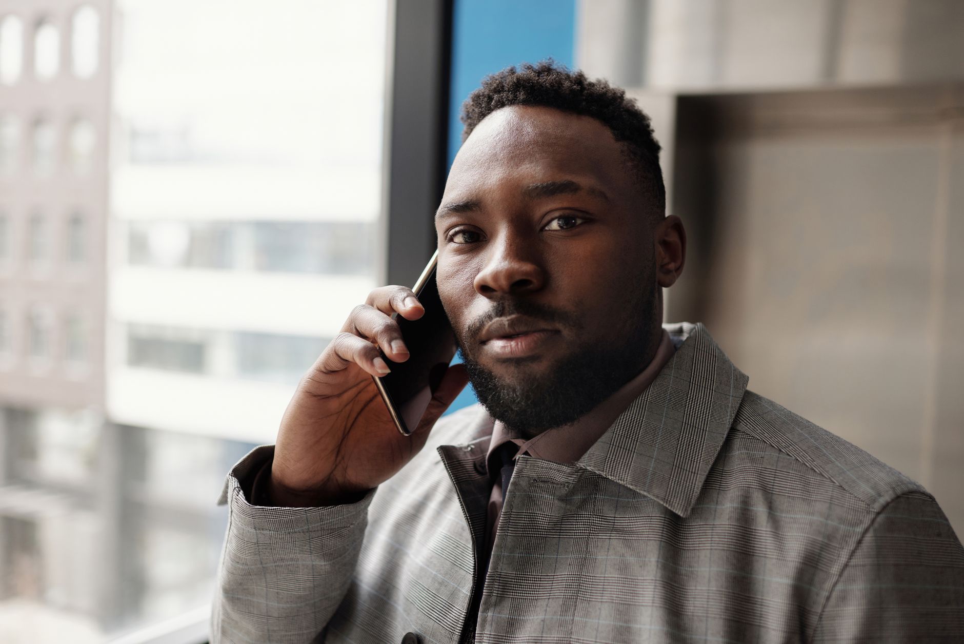 A man in a suit making a phone call in an office