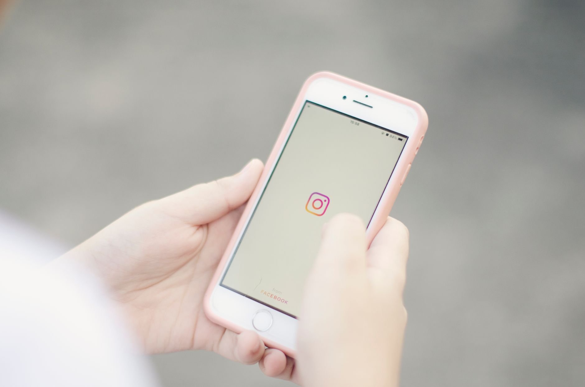 A person holding a smartphone with a social media app open