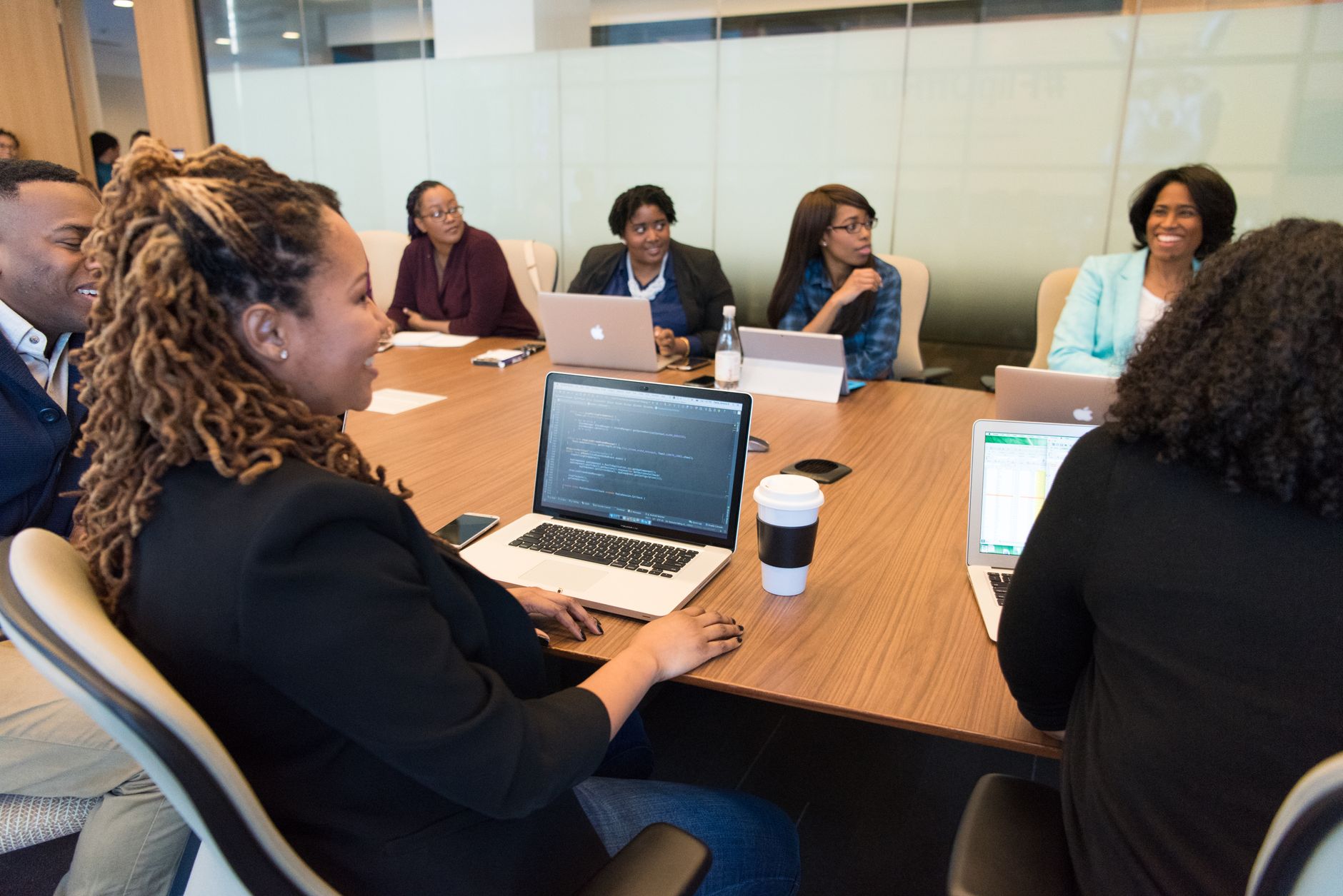 A group of professionals working with laptops in a conference room