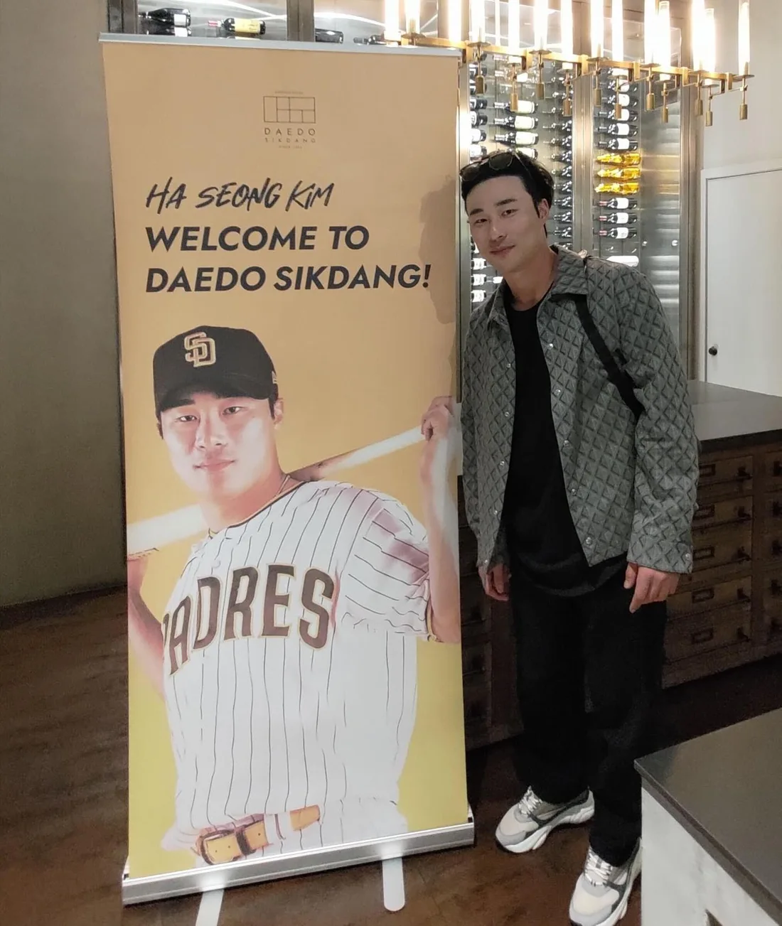 Padres star Ha Seong Kim beside the welcome banner at Daedo Sikdang