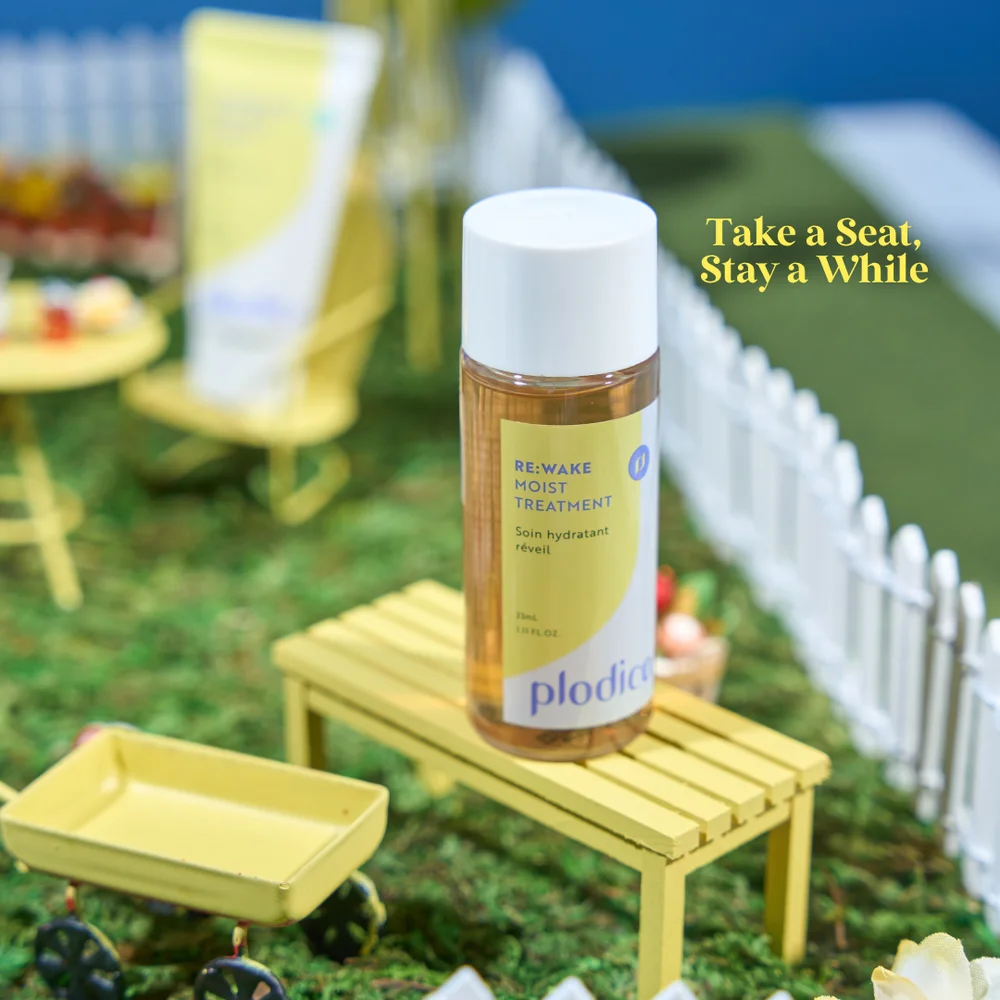 RE:WAKE Moist Treatment on a tiny yellow bench inside a miniature garden