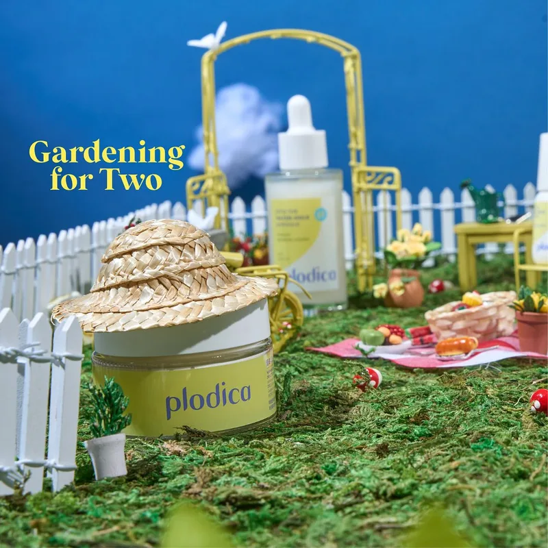 Miniature gardening scene with straw hats around a Plodica ampoule